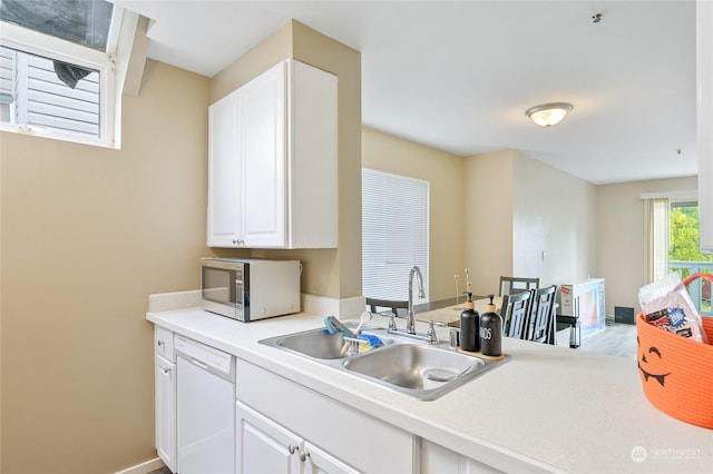 10335 Midvale Ave N, Seattle, WA 98133 - kitchen featuring stainless steel microwave, a sink, white dishwasher, light countertops, and white cabinetry