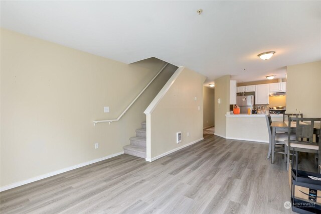 10335 Midvale Ave N, Seattle, WA 98133 - unfurnished living room with light wood-type flooring, stairs, and baseboards