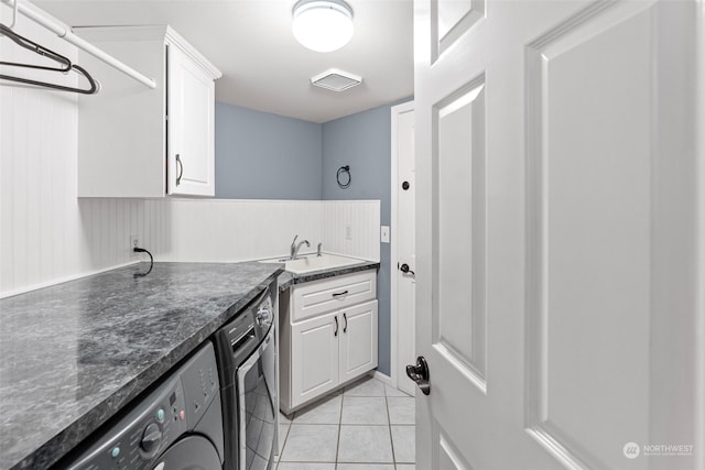 clothes washing area with washing machine and dryer, sink, and light tile patterned floors