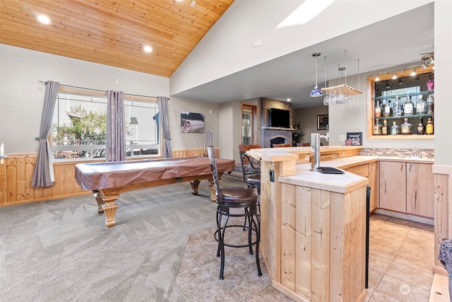 rec room with wooden walls, light carpet, wooden ceiling, indoor wet bar, and a fireplace