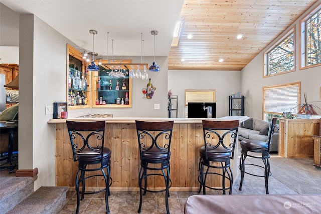 bar with pendant lighting, lofted ceiling, and wood ceiling