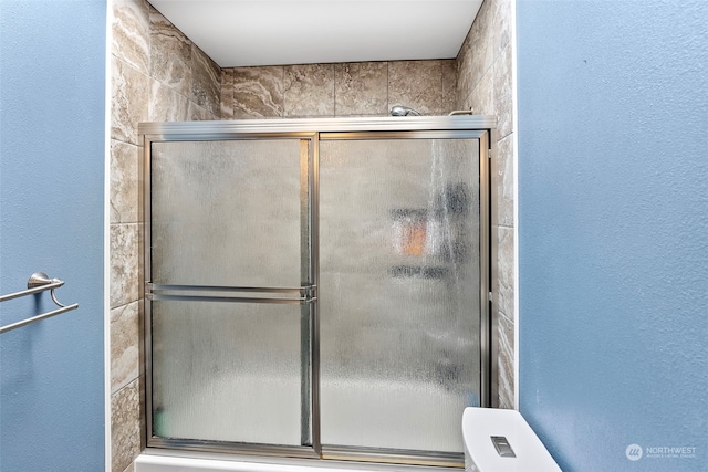 bathroom with toilet and an enclosed shower