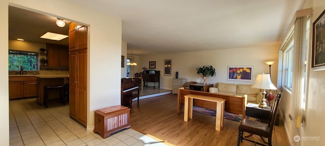 living room with light hardwood / wood-style floors, sink, and a chandelier