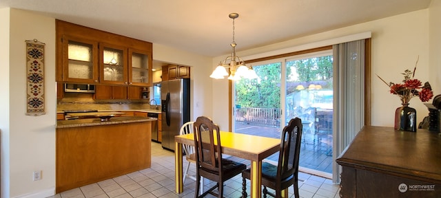 dining area featuring light tile patterned flooring and a notable chandelier