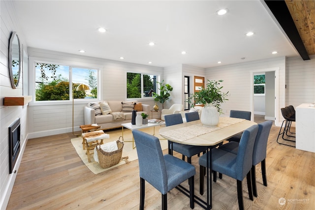 dining room featuring beam ceiling and light hardwood / wood-style floors