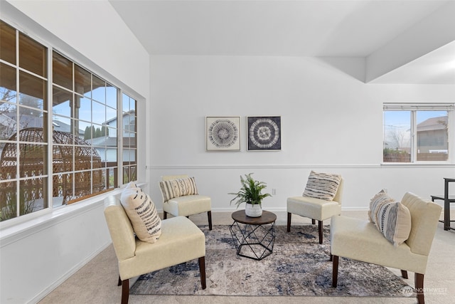 living area with plenty of natural light and light colored carpet