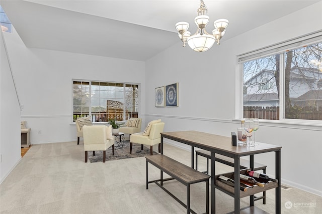 dining area featuring light carpet and an inviting chandelier