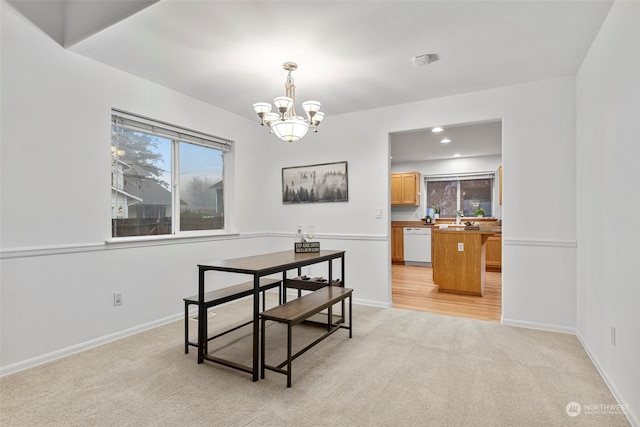 dining room featuring light carpet, an inviting chandelier, and sink