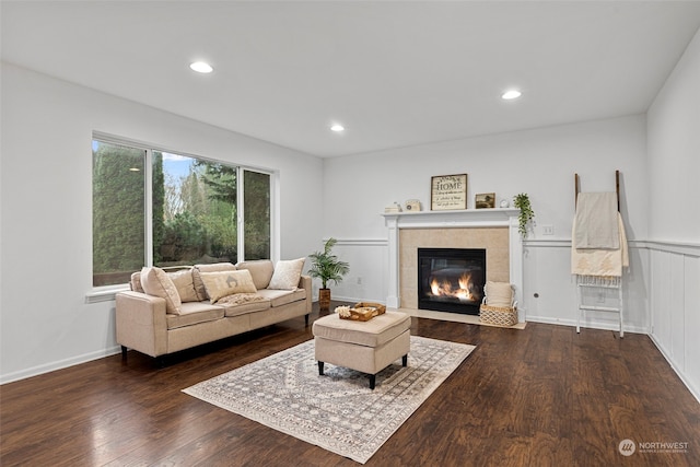 living room featuring dark hardwood / wood-style flooring and a tiled fireplace