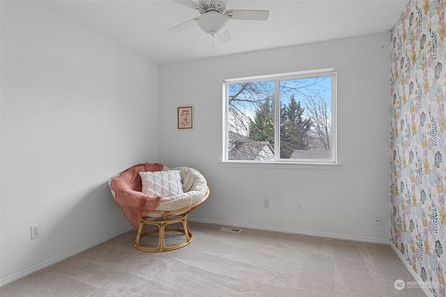 living area with carpet flooring and ceiling fan