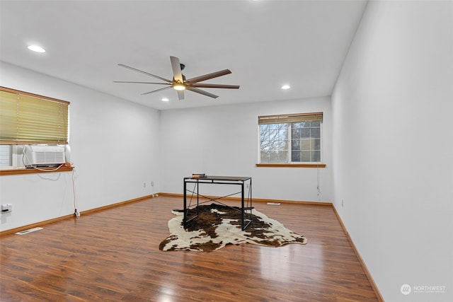 interior space featuring ceiling fan, cooling unit, and wood-type flooring