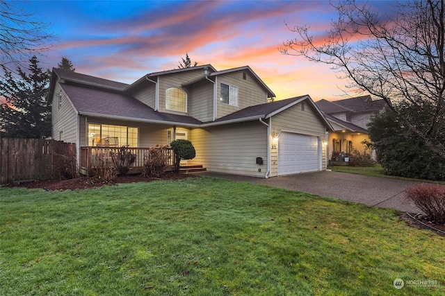 front of property with covered porch, a yard, and a garage