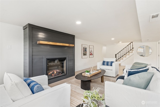 living room featuring a large fireplace and light hardwood / wood-style flooring