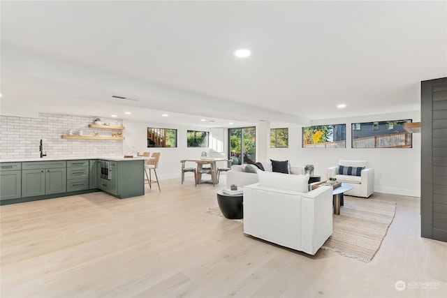 living room with light hardwood / wood-style flooring and indoor wet bar