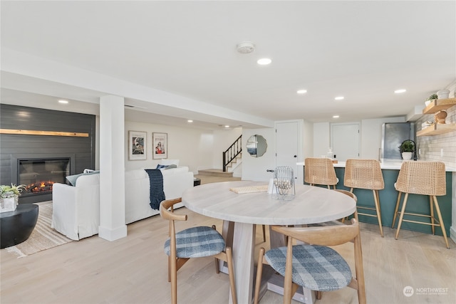 dining space with light wood-type flooring and a fireplace