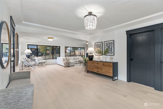 bedroom with light wood-type flooring, a textured ceiling, and a notable chandelier