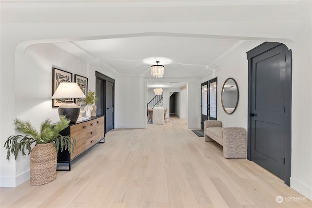 hall featuring light hardwood / wood-style flooring and a chandelier