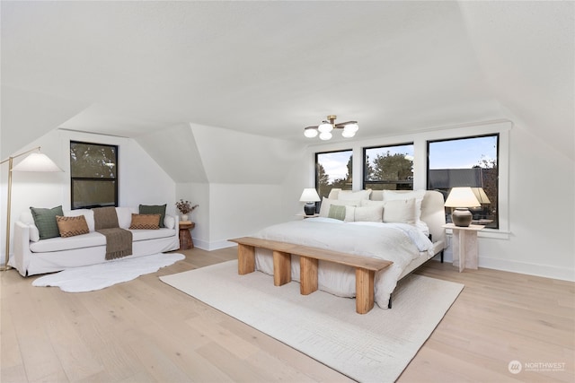 bedroom with light hardwood / wood-style floors and lofted ceiling