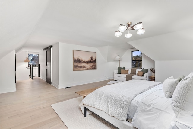 bedroom with an inviting chandelier, light wood-type flooring, and vaulted ceiling