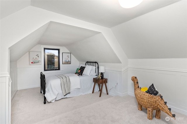 bedroom featuring light colored carpet and vaulted ceiling