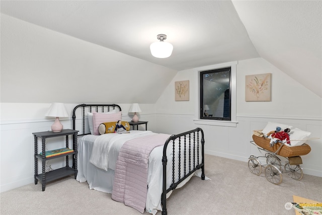 bedroom with light colored carpet and lofted ceiling