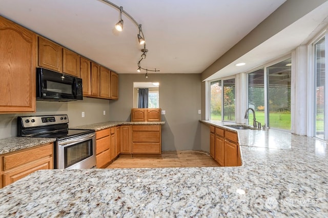 kitchen featuring a wealth of natural light, sink, stainless steel range with electric stovetop, and light hardwood / wood-style flooring