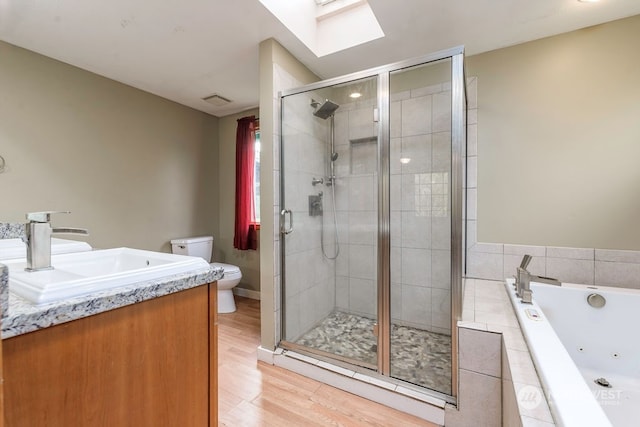 full bathroom featuring wood-type flooring, vanity, plus walk in shower, toilet, and a skylight