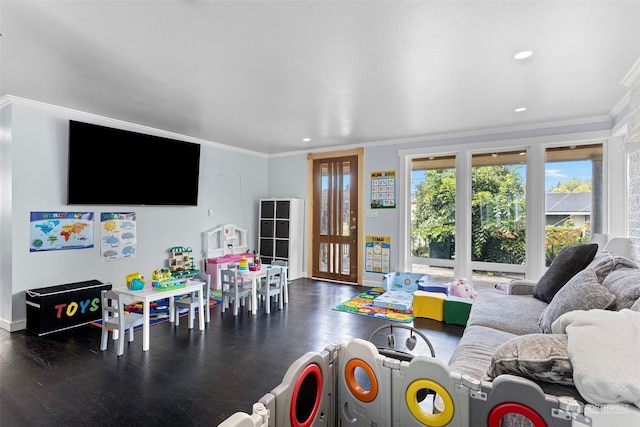 rec room with dark hardwood / wood-style floors and ornamental molding