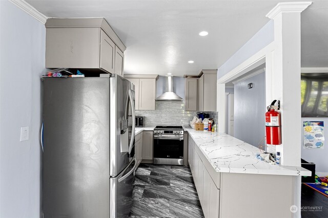 kitchen featuring light stone counters, crown molding, appliances with stainless steel finishes, kitchen peninsula, and wall chimney exhaust hood