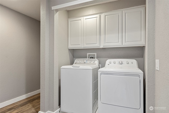 laundry room with washer and dryer, dark hardwood / wood-style floors, and cabinets