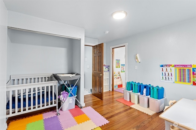 bedroom featuring hardwood / wood-style flooring and a nursery area