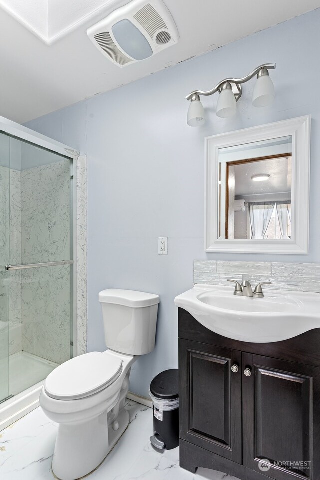 bathroom with a shower with door, vanity, and toilet