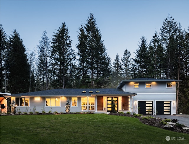 view of front of home featuring a garage and a yard