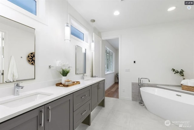 bathroom with a washtub, vanity, and plenty of natural light