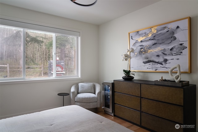 bedroom with wine cooler and hardwood / wood-style floors