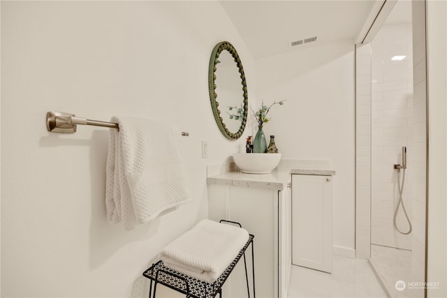 bathroom featuring tiled shower and sink