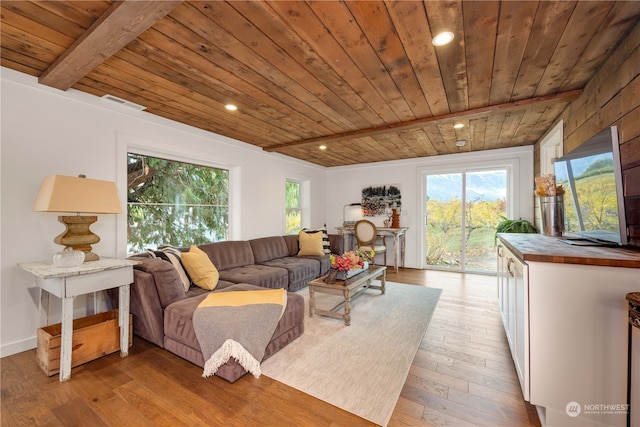 living room with light hardwood / wood-style floors, beam ceiling, and wooden ceiling