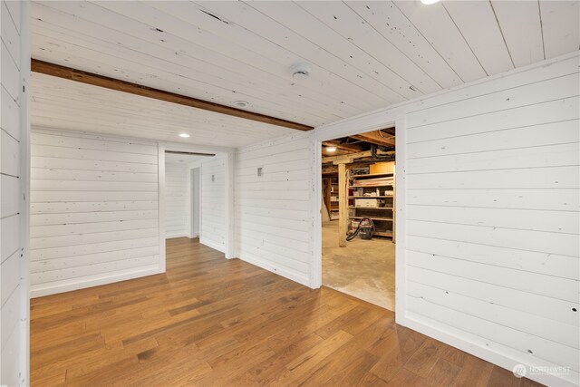 spare room with wood walls, wood ceiling, and wood-type flooring