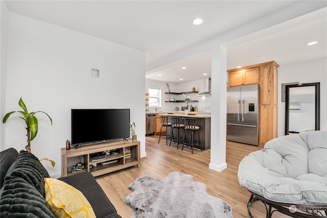 living room featuring a wall unit AC and light hardwood / wood-style floors