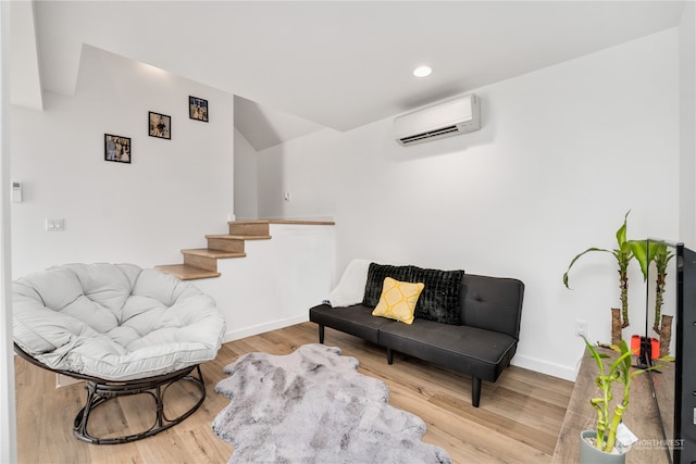 sitting room with light wood-type flooring and an AC wall unit