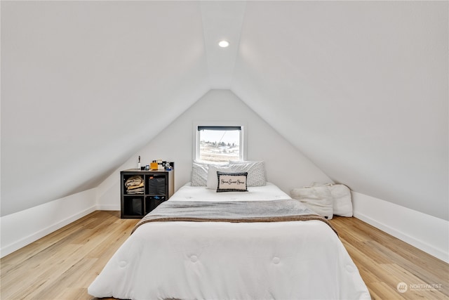 bedroom with lofted ceiling and hardwood / wood-style floors