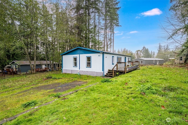 rear view of property featuring a lawn and a wooden deck