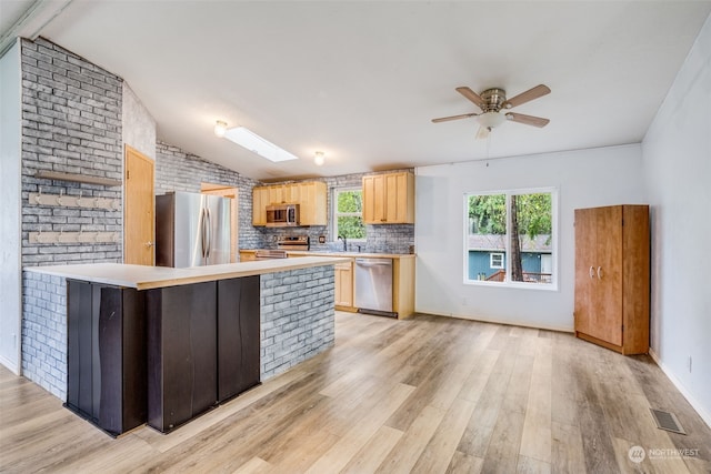 kitchen with light wood-type flooring, lofted ceiling, and appliances with stainless steel finishes