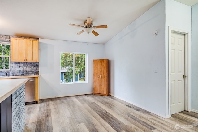 interior space with ceiling fan, light brown cabinets, decorative backsplash, light hardwood / wood-style floors, and dishwasher