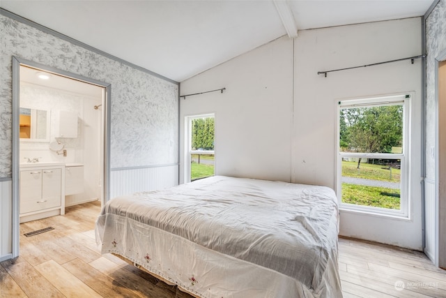 bedroom with vaulted ceiling with beams, light hardwood / wood-style floors, and multiple windows