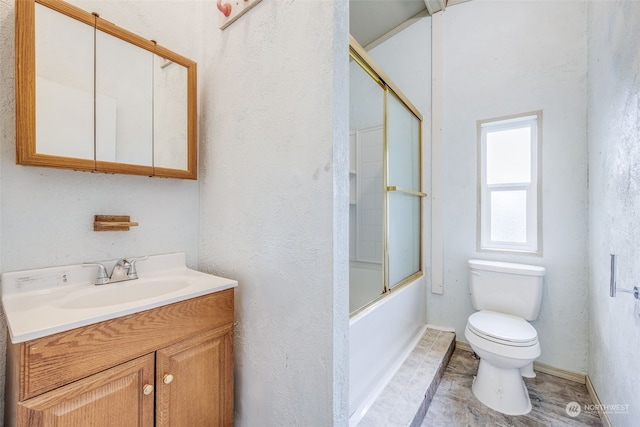 full bathroom featuring combined bath / shower with glass door, vanity, and toilet