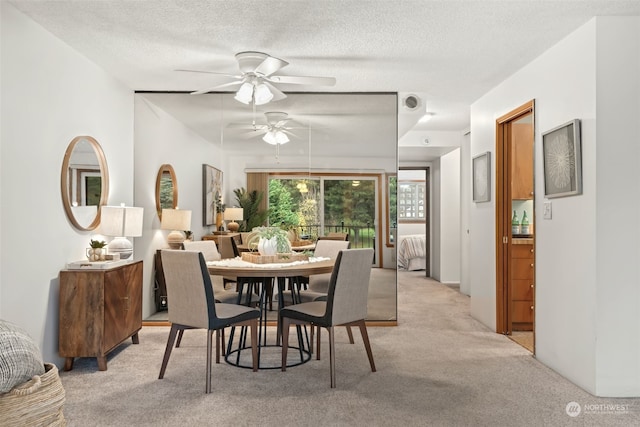 carpeted dining area featuring ceiling fan and a textured ceiling