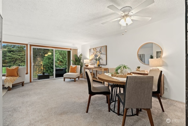 dining area with ceiling fan, light colored carpet, and a textured ceiling