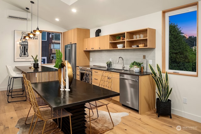 kitchen with appliances with stainless steel finishes, hanging light fixtures, light brown cabinetry, and sink