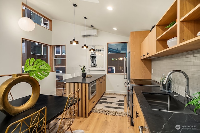 kitchen with black range with electric stovetop, sink, an AC wall unit, decorative light fixtures, and light hardwood / wood-style floors